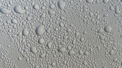 Dewdrops fall on the metal surface, creating a beautiful water bubble texture