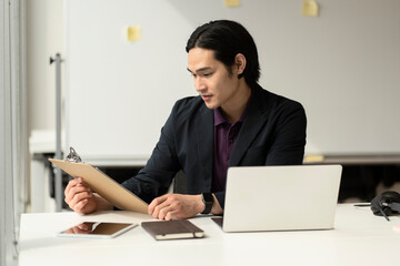 Handsome asian man, manager  reading contract working in modern office. Successful business 