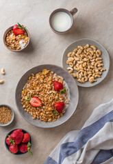 Bowl of granola with strawberries, cashew nuts. Breakfast muesli with milk and berries. view from above