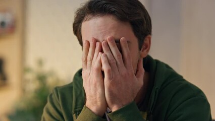 Disappointed man covering face palm in office closeup. Tired creator worried - Powered by Adobe