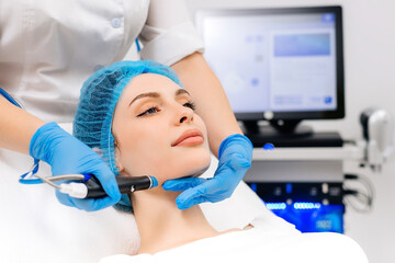 Naklejka premium Beauty therapist performing hydrafacial procedure on woman
