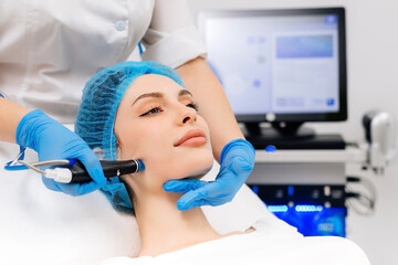 Naklejka premium Beauty therapist performing hydrafacial procedure on woman