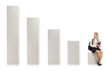 Female college student sitting on a bar chart and looking at rising columns