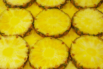 Pineapple juicy yellow slices as a background.