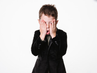 Portrait of surprised child with hands on cheeks standing on white background.