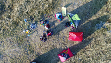 Group of people enjoying tent camping in mountains (aerial view, car not recognizable)