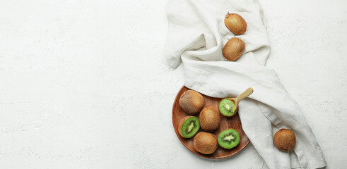 Plate with fresh kiwi on white background with space for text, top view