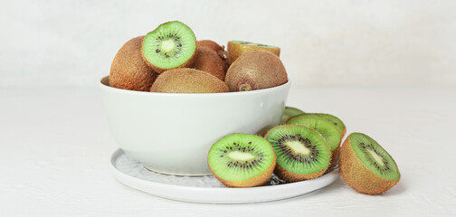 Bowl with fresh ripe kiwi on light background