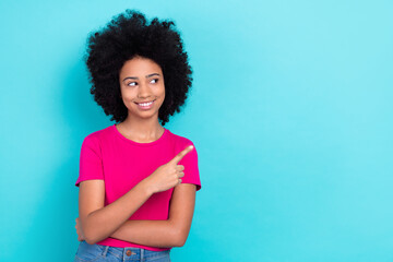 Photo of dreamy charming small lady wear pink t-shirt pointing finger looking empty space isolated turquoise color background