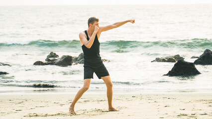 young man fighting with a shadow on the ocean coastline