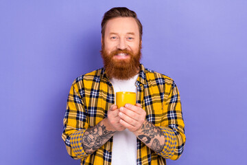 Portrait of positive satisfied young person beaming smile arms hold fresh coffee cup isolated on purple color background