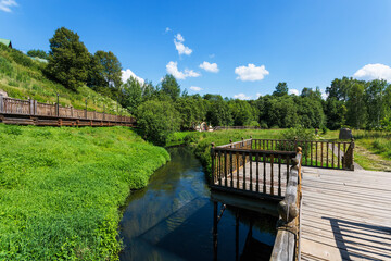 Fototapeta na wymiar Wooden bridge across the river in the village. Russia, Moscow region