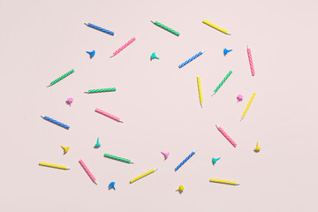 Frame made of colorful birthday candles on pink background