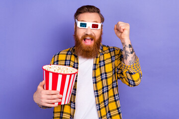 Photo of overjoyed glad man wear stylish plaid clothes relax rest enjoy watching interesting movie isolated on purple color background