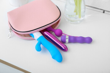 Bag with sex toys on table in room, closeup