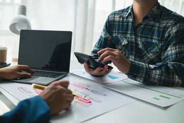 Businessmen and investors form a group of startups and business plans together in a meeting room. A group of startup entrepreneurs are discussing investment plans and profits.