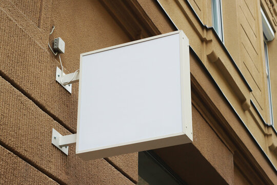 Blank white store sign design mockup. Street storefront shop, cafe, restaurant mounted signboard mock up design template.