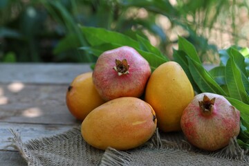 Pomegranate and mango, on the table, exotic fruits, background image, summer, vitamins