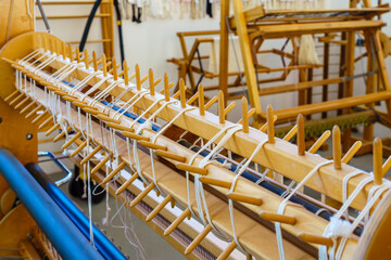Close-up of a floor loom sectional warping dowels in a textile weaving studio