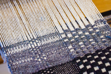 Close-up textile weaving with wool thread yarn on a loom
