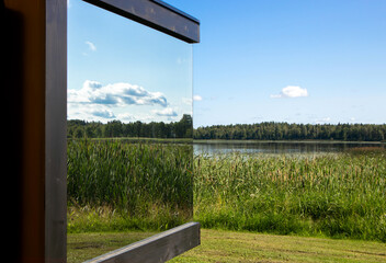 Detail view of modern mirror reflective window on building in the middle of wild nature. Luxury...