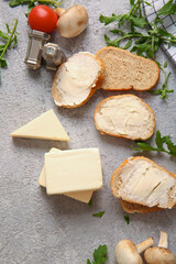 Sandwiches with processed cheese and herbs on grunge background
