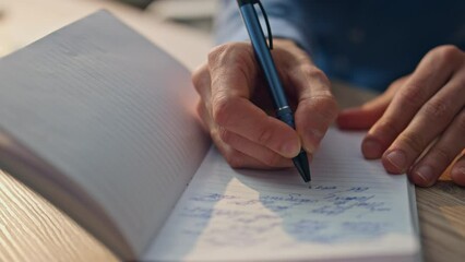 Closeup author hands writing notebook in office. Creative man noticing on paper