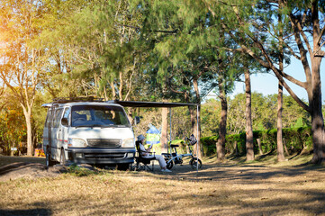 Asian woman travel and camping alone by camper van at park in Thailand. Recreation and journey outdoor activity lifestyle.