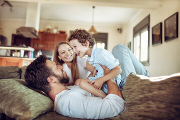 Young family playing together on the couch in the living room