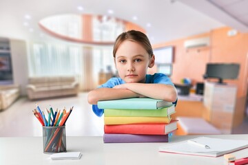 Back to school concept. Sad school kid studying at home