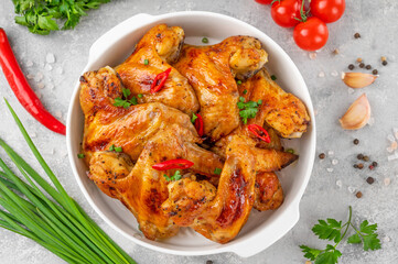 Baked chicken wings served with sweet chili sauce and fresh herbs. Selective focus.