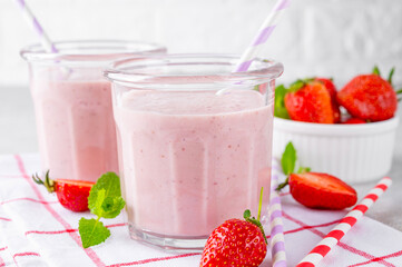 Strawberry milkshake or smoothie cocktail in the glass jar on a gray concrete background. Copy space.