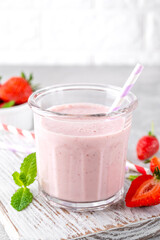 Strawberry milkshake or smoothie cocktail in the glass jar on a gray concrete background. Copy space.