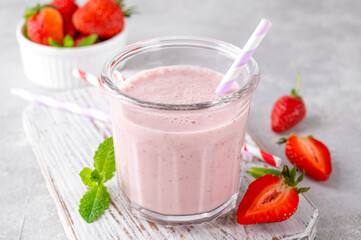 Strawberry milkshake or smoothie cocktail in the glass jar on a gray concrete background. Copy space.