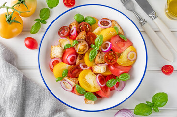 traditional Italian Panzanella salad with tomatoes, onion, fresh basil and bread. Vegetarian dish. top view