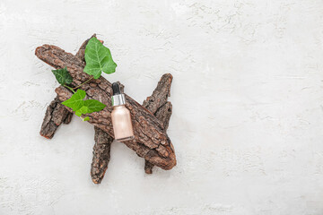 Bottle of highlighter with leaves and tree bark on white background