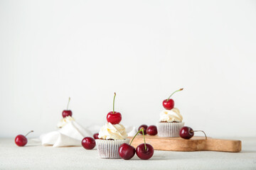 Tasty cherry cupcake on light background