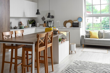 Interior of light kitchen with modern appliances on wooden table