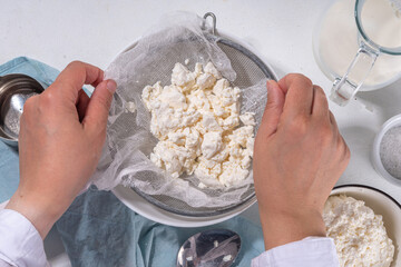 Making cottage cheese, homemade fermenting dairy product. Homemade cottage cheese in cheesecloth...