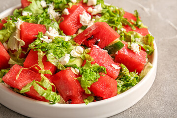 Plate of tasty watermelon salad on grey background