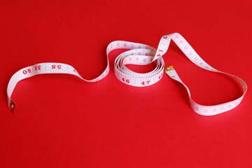 white tape measuring isolated on a red background