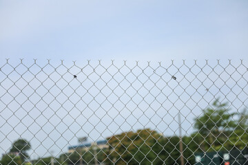 Chain-link fence symbolizes boundaries, security and isolation. Metaphor for protection and confinement. Concept of division and connection