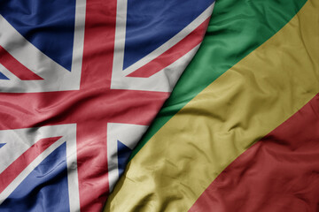 big waving national colorful flag of great britain and national flag of republic of the congo .