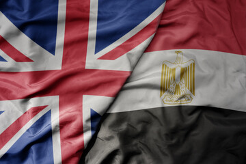 big waving national colorful flag of great britain and national flag of egypt .