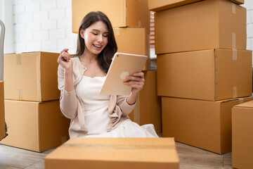 Beautiful woman use tablet computer  online selling product with cardboard box 