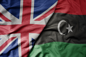 Fototapeta premium big waving national colorful flag of great britain and national flag of libya .