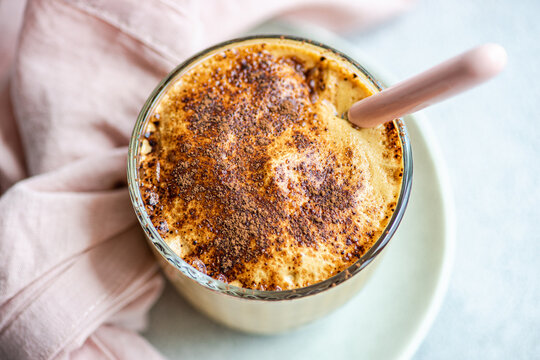 Glass cup with coffee cream dessert with chocolate powder and ice
