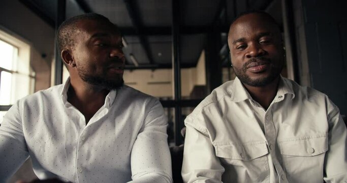 First-person view video conference of 2 black businessmen in white shirts who emotionally talk about their plans and business