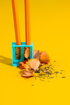 Pencil in blue sharpener on yellow table