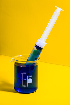Syringe in jar with blue liquid